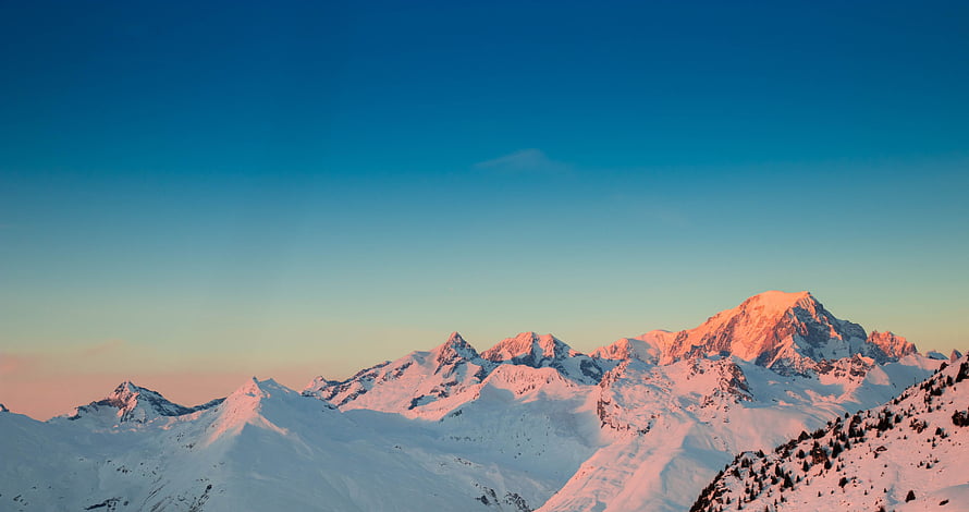 Alpine Mountain Range Bathed in Golden Sunset Light with Snow-Capped Peaks HD wallpaper