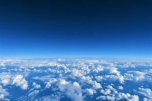 Aerial View of Fluffy White Clouds Against a Deep Blue Sky HD wallpaper