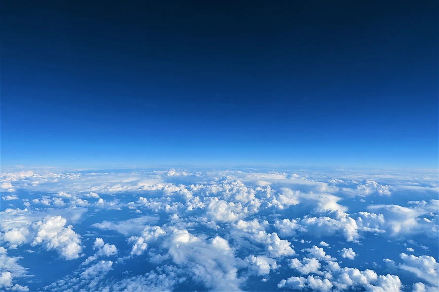 Aerial View of Fluffy White Clouds Against a Deep Blue Sky HD wallpaper