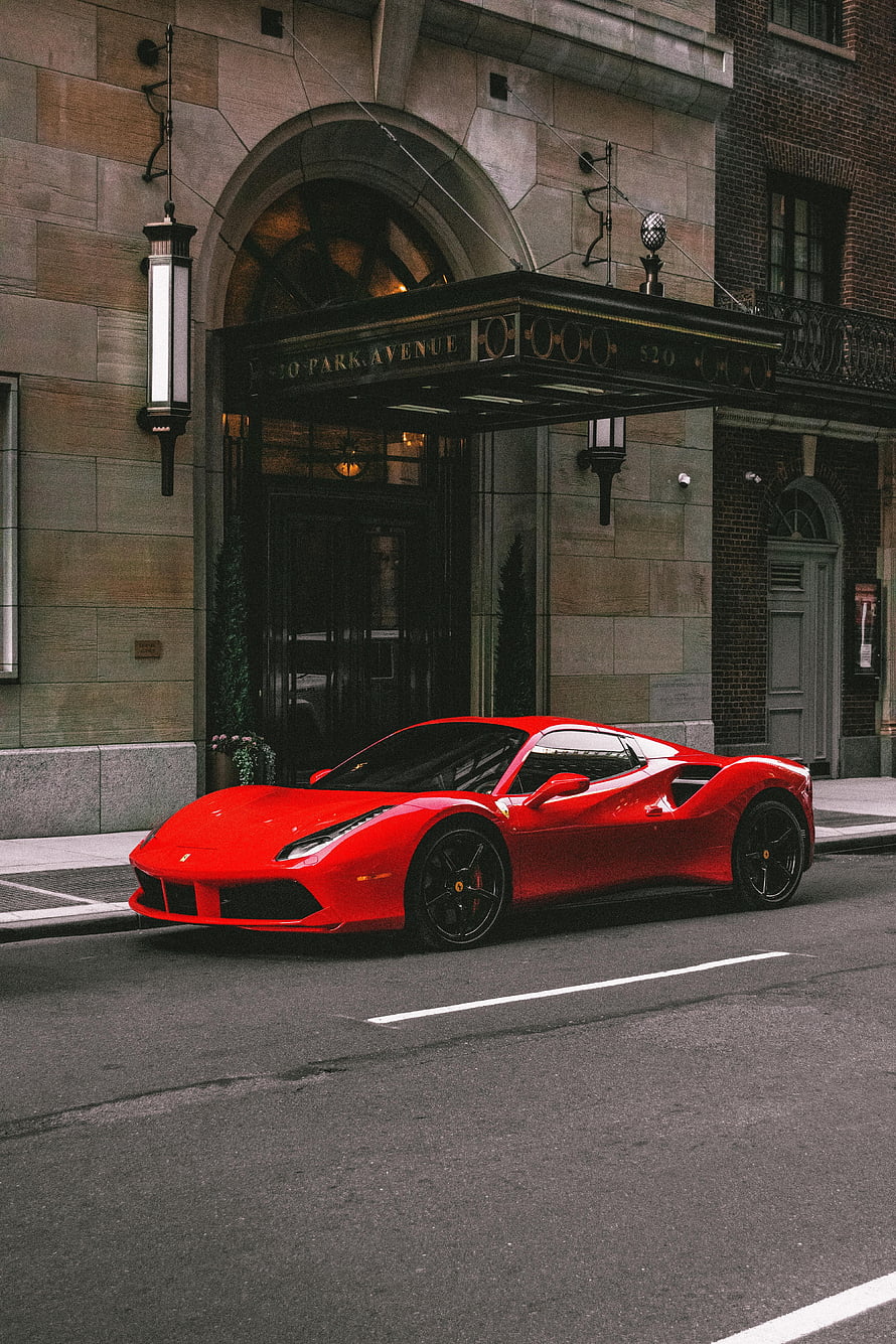 Red Ferrari 488 GTB parked on city street in front of 520 Park Avenue building entrance HD phone wallpaper