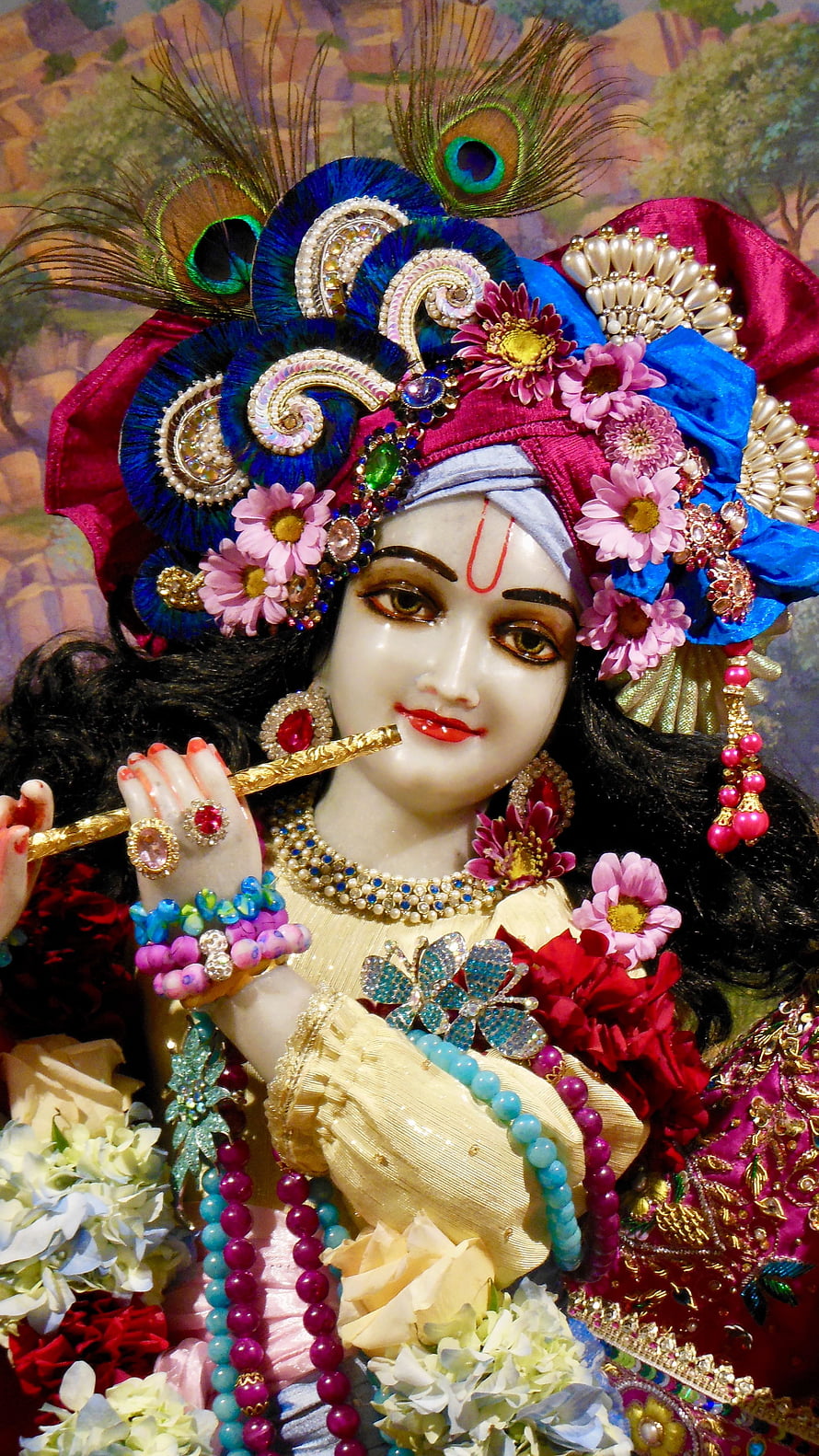 Ornate Krishna Murti Statue Adorned With Peacock Feathers, Flowers, and Jewels HD phone wallpaper