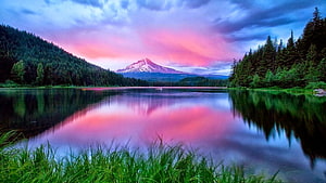 Snow-capped mountain reflected in a calm lake at sunset with pink and purple sky HD wallpaper