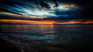 Dramatic Sunset Over Ocean With Dark Stormy Clouds And Golden Horizon Reflection HD wallpaper