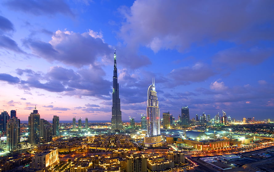 Dubai skyline at dusk featuring the Burj Khalifa and Burj Al Arab illuminated against a dramatic purple and blue sky HD wallpaper