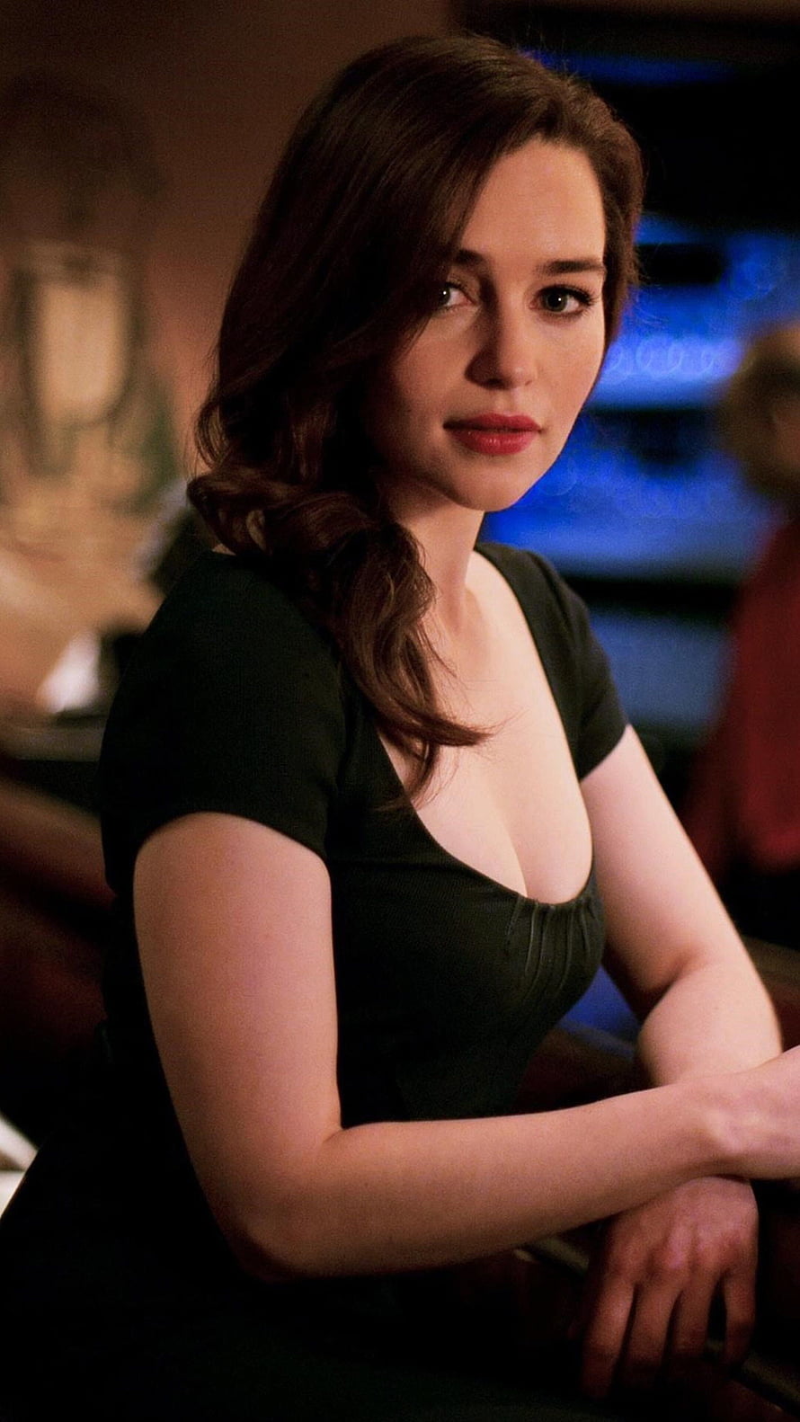 Emilia Clarke in a dark green dress with warm cinematic lighting and a moody background HD phone wallpaper