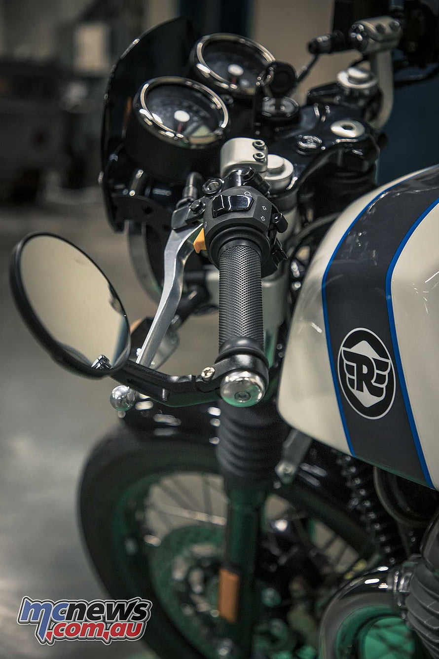 Close-up of a custom Triumph motorcycle handlebar with analog gauges and tank logo HD phone wallpaper