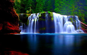 Serene Waterfall Cascading Into A Deep Blue Pool Surrounded By Lush Green Forest HD wallpaper