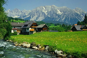 Alpine Village with Traditional Chalets and Mountain Backdrop HD wallpaper