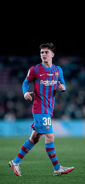 Barça player in blue and red striped kit running on the pitch HD phone wallpaper