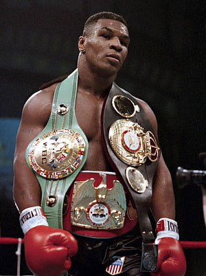 Mike Tyson wearing multiple championship boxing belts in the ring HD phone wallpaper