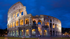 Colosseum in Rome at Night with Warm Illumination Against a Deep Blue Sky HD wallpaper