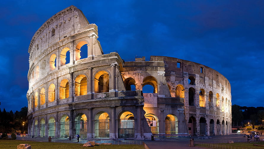 Colosseum in Rome at Night with Warm Illumination Against a Deep Blue Sky HD wallpaper