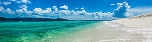 Turquoise Lagoon Meets White Sand Beach Under a Bright Blue Sky HD wallpaper