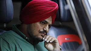 Sidhu Moose Wala in Red Turban and Green Shirt with Thoughtful Expression HD wallpaper