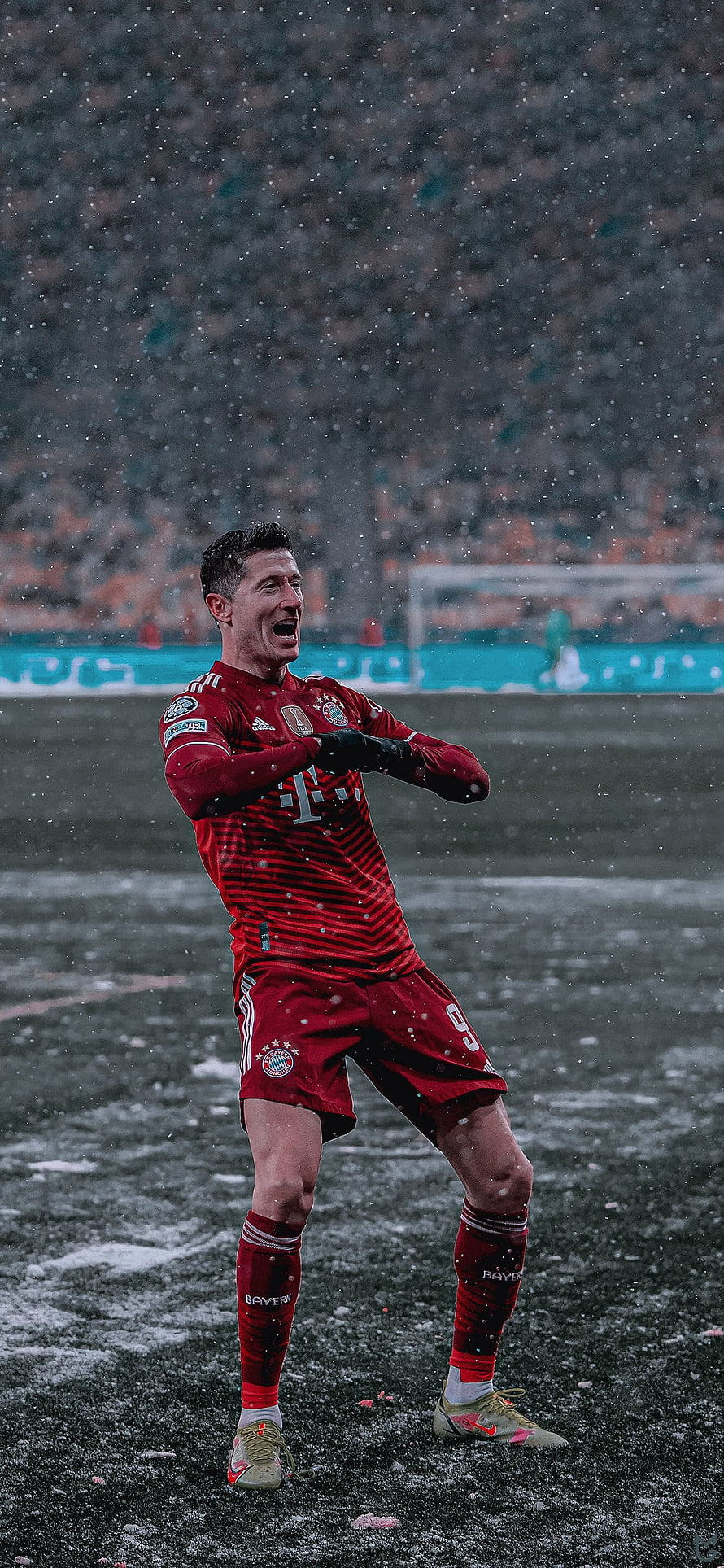 Robert Lewandowski in Bayern Munich kit celebrating on a snowy football pitch HD phone wallpaper