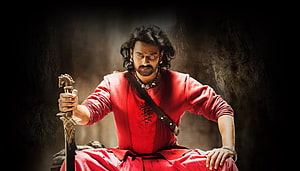Prabhas as Baahubali in Red Attire Holding Sword in Dramatic Pose HD wallpaper