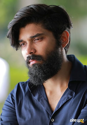 Dhruv Vikram in a thoughtful close-up portrait wearing a dark blue shirt HD phone wallpaper