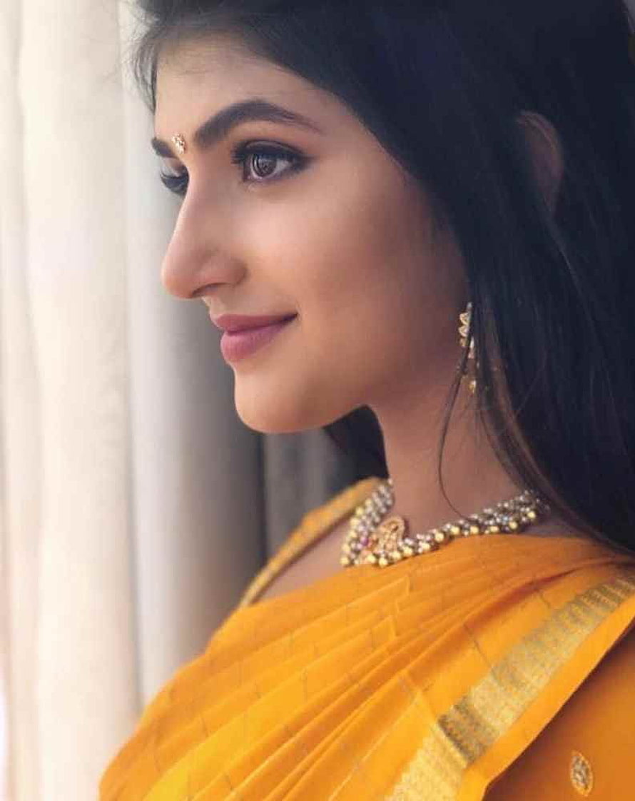 Sree Leela in a golden yellow saree with traditional jewelry and a bindi HD phone wallpaper