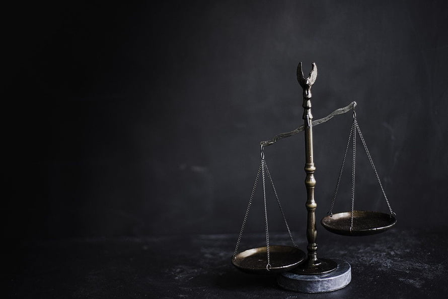 Vintage brass balance scale on a dark textured surface with dramatic moody lighting HD wallpaper