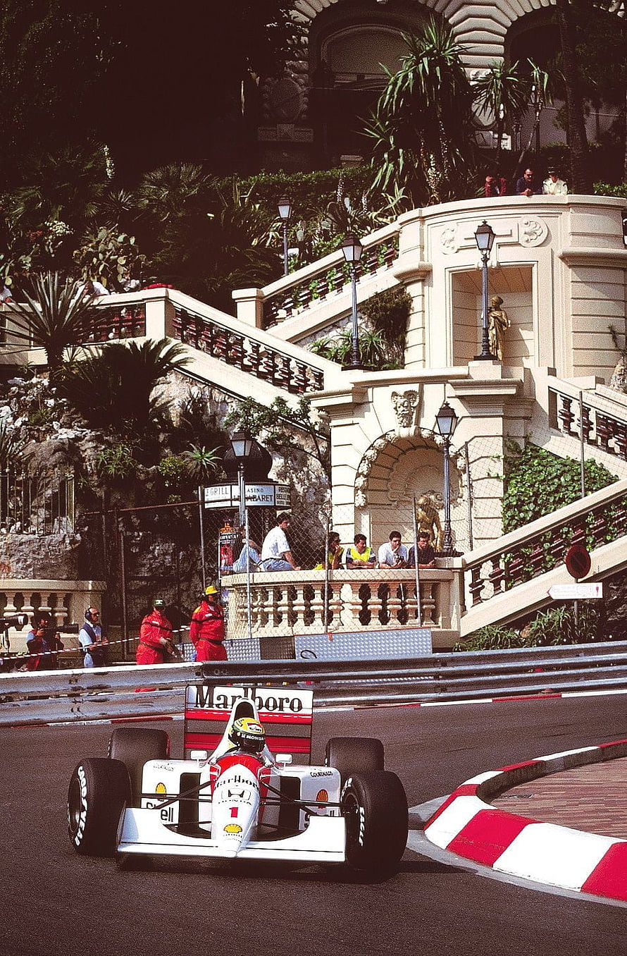 Michael Schumacher driving a white and red Marlboro McLaren Formula 1 car around a corner at the Monaco Grand Prix HD phone wallpaper