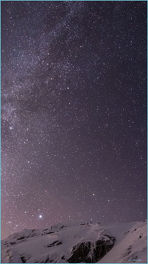 Milky Way Galaxy Arching Over Snow-Capped Mountain Ridge at Night HD phone wallpaper