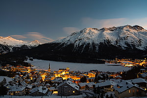 St. Moritz Winter Village at Dusk with Snow-Capped Mountains and Frozen Lake HD wallpaper