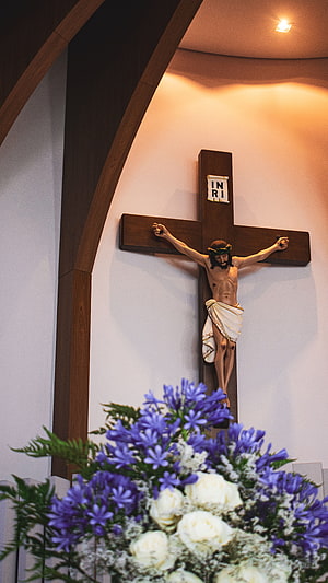 Jesus Christ on the Cross with Purple and White Flowers in Church HD phone wallpaper