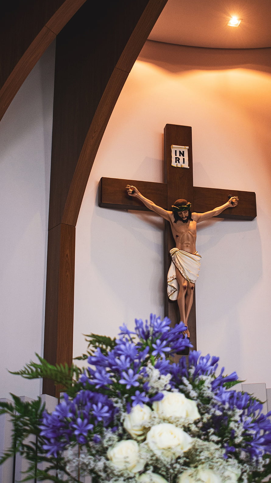 Jesus Christ on the Cross with Purple and White Flowers in Church HD phone wallpaper