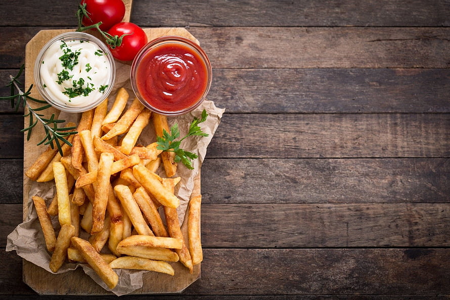 Golden French Fries with Ketchup and Mayonnaise on a Rustic Wooden Board HD wallpaper
