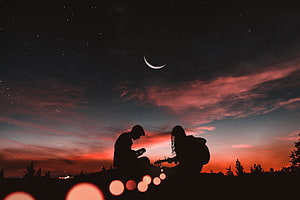 Couple Playing Guitar Silhouetted Against a Starry Sky with Crescent Moon and Vibrant Sunset HD wallpaper