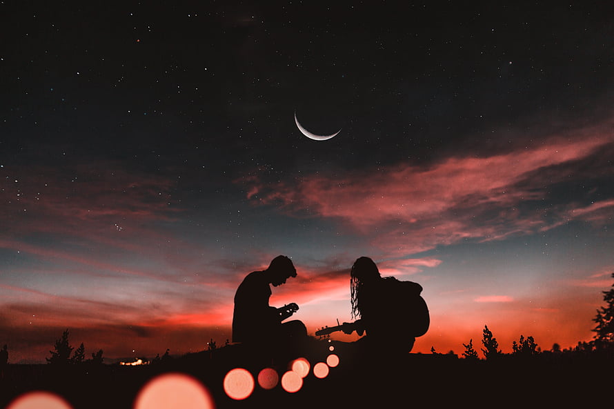 Couple Playing Guitar Silhouetted Against a Starry Sky with Crescent Moon and Vibrant Sunset HD wallpaper