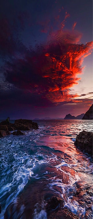 Dramatic Crimson Sunset Over Rocky Ocean Coastline with Turbulent Waves HD phone wallpaper