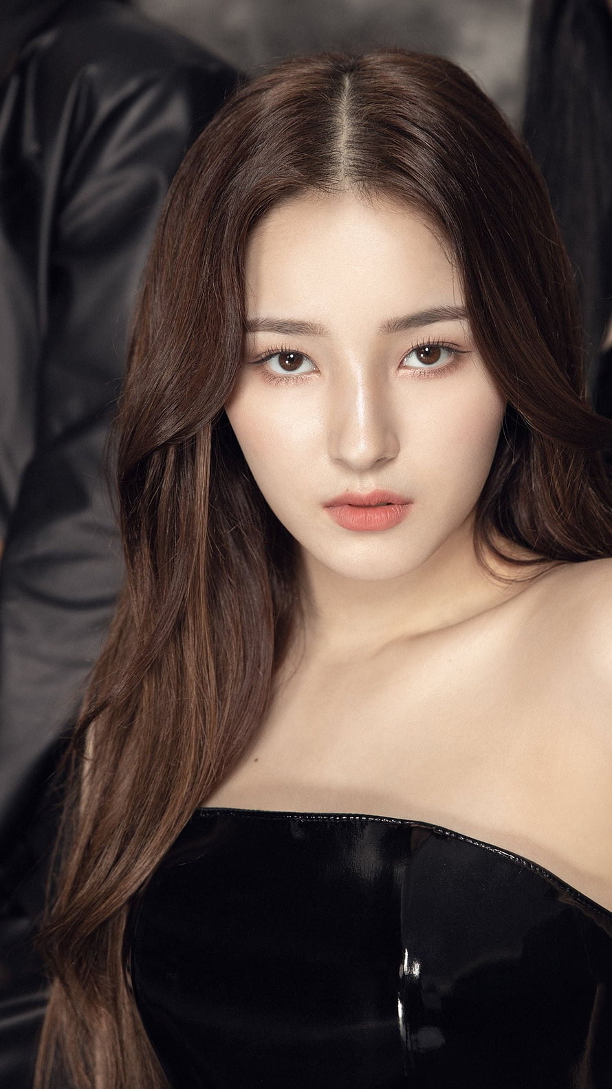 Nancy from Momoland in a sleek black latex strapless top with long brown hair and elegant makeup HD phone wallpaper