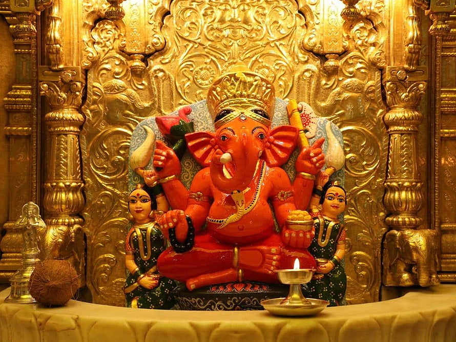 Vibrant Red Ganesha Idol with Golden Temple Background and Offerings HD wallpaper
