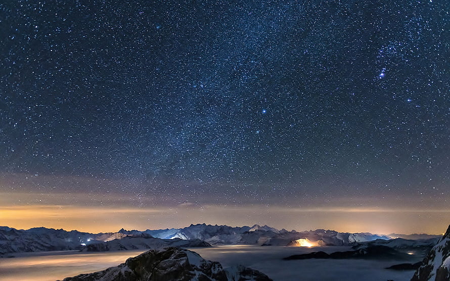Starry Night Sky Over Snow-Capped Mountain Range With Glowing Horizon HD wallpaper
