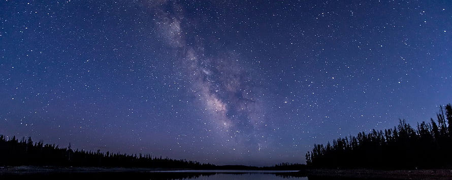 Milky Way Galaxy Arching Over a Serene Nighttime Lake and Forest Silhouette HD wallpaper
