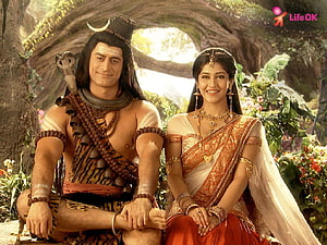 Shiva and Parvati Sitting Together in a Lush Forest Setting HD wallpaper