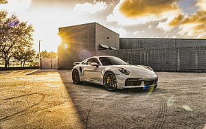 White Porsche 911 Turbo S parked in front of a modern building at sunset HD wallpaper