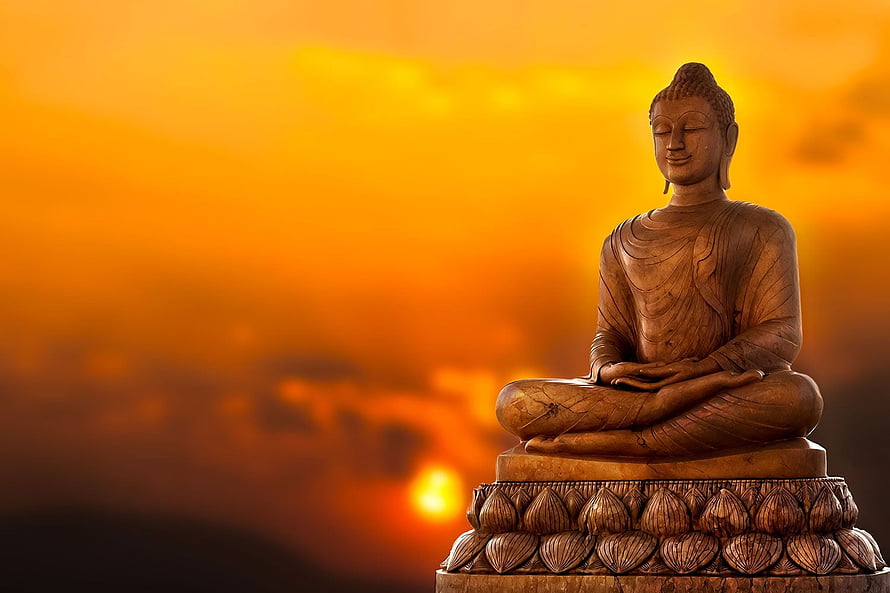 Serene Buddha Statue in Meditation Against a Golden Sunrise Sky HD wallpaper