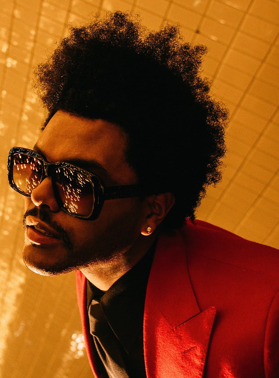 The Weeknd in a red suit and sunglasses against a warm golden tiled background HD phone wallpaper