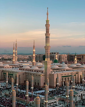 Al-Masjid an-Nabawi in Medina at sunset with illuminated minarets and green dome HD phone wallpaper