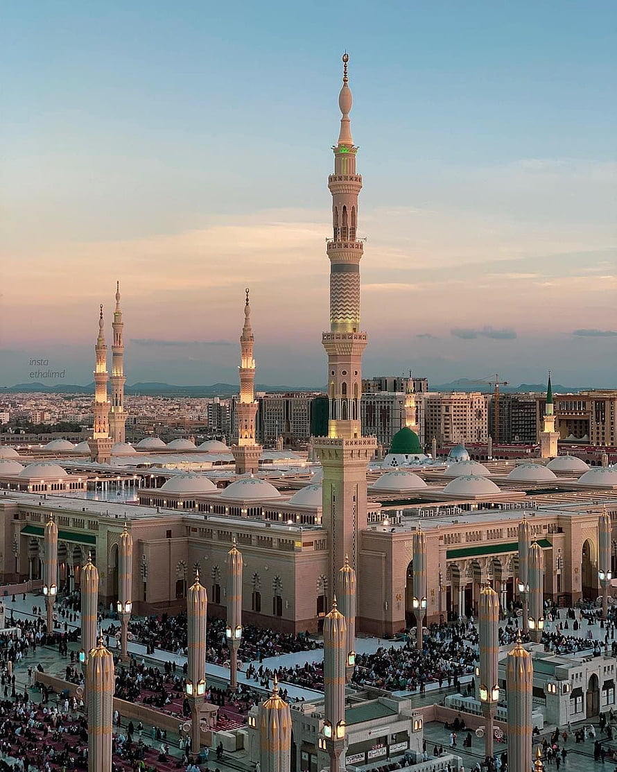 Al-Masjid an-Nabawi in Medina at sunset with illuminated minarets and green dome HD phone wallpaper