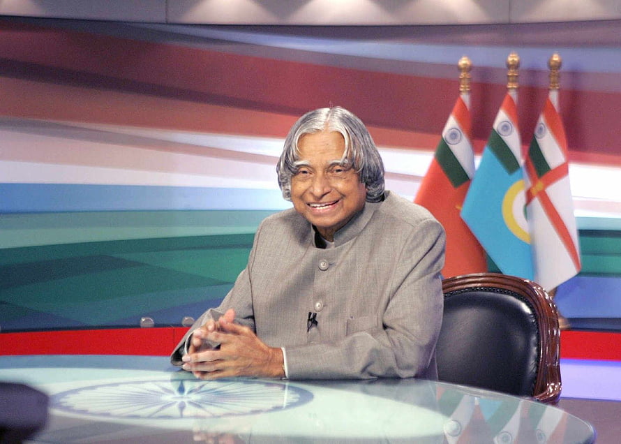 APJ Abdul Kalam Seated at a News Desk with Indian Flags in the Background HD wallpaper