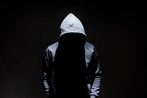 Mysterious Hooded Figure in Dramatic Shadow HD wallpaper