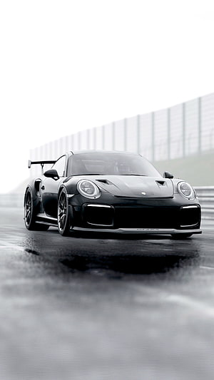 Black Porsche 911 GT2 RS on a wet racetrack with dramatic lighting HD phone wallpaper