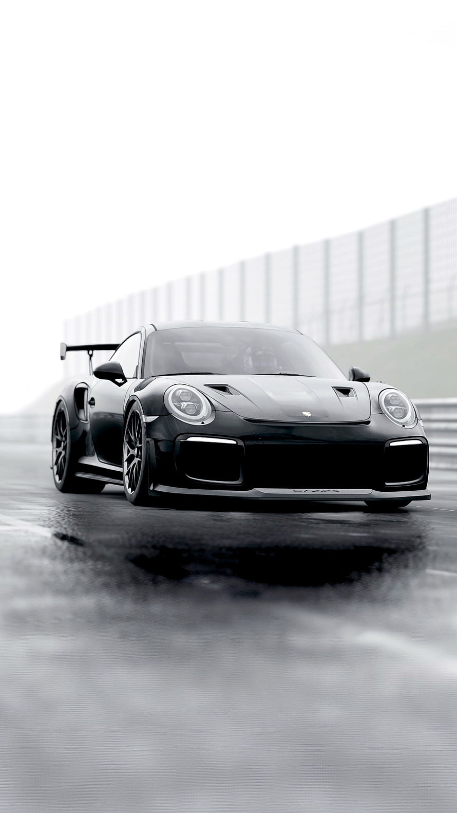 Black Porsche 911 GT2 RS on a wet racetrack with dramatic lighting HD phone wallpaper