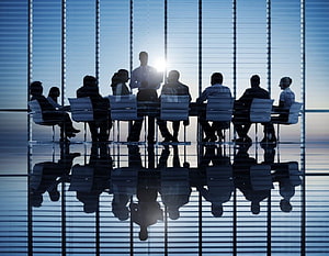 Silhouettes of business team meeting in modern office with reflective floor HD wallpaper