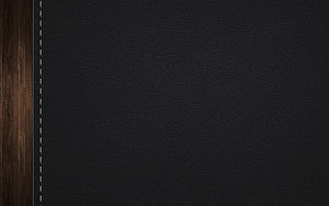 Dark Leather Notebook Cover with White Stitching on Wooden Surface HD wallpaper