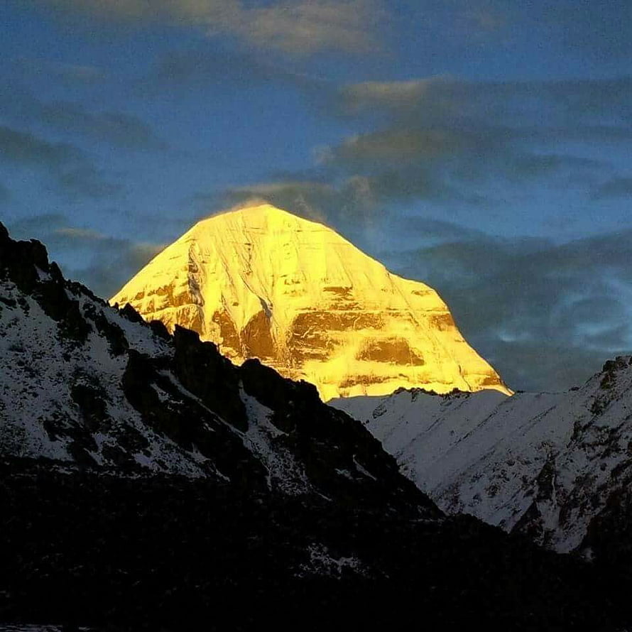 Mount Kailash glowing golden at sunrise above snow-covered Himalayan ridges HD phone wallpaper