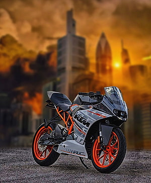 KTM RC390 sport motorcycle with orange frame parked against a golden sunset city skyline HD phone wallpaper